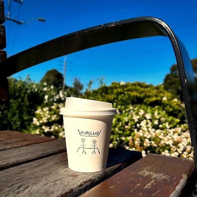 A Homeland Cafe takeaway cup out in the sunshine